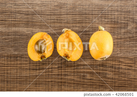 Fresh raw orange japanese loquat on brown wood 42068501