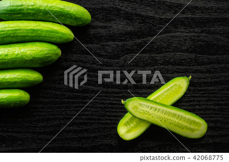 Fresh raw mini cucumber on black wood 42068775