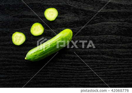 Fresh raw mini cucumber on black wood Fresh raw mini cucumber on black wood 42068776