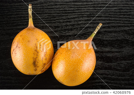 Fresh raw Grenadilla on black wood Fresh raw Grenadilla on black wood 42068976