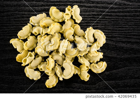 Fresh raw paste Creste di Gallo on black wood Fresh raw paste Creste di Gallo on black wood 42069435