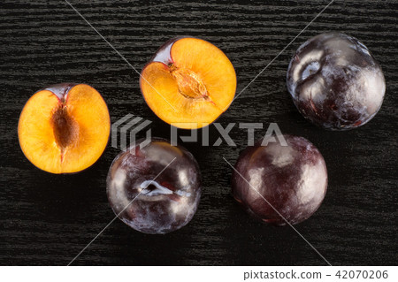 Red Blue Plums on black wood Red Blue Plums on black wood 42070206