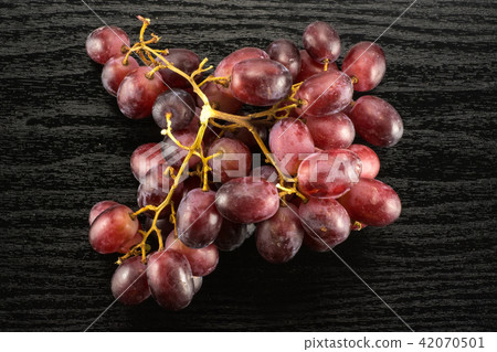 Raw fresh red globe grape on black wood 42070501