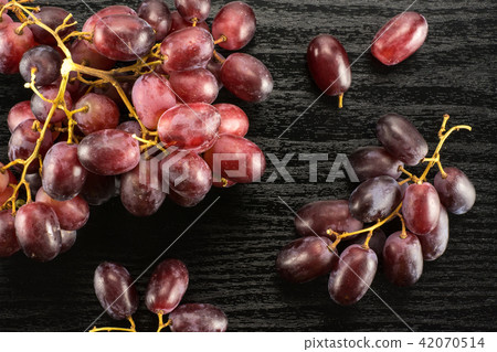 Raw fresh red globe grape on black wood Raw fresh red globe grape on black wood 42070514