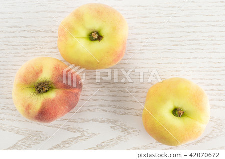 Fresh raw saturn peach on grey wood Fresh raw saturn peach on grey wood 42070672