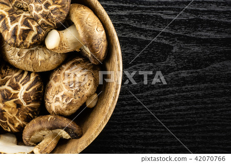 Fresh raw shitake mushroom on black wood Fresh raw shitake mushroom on black wood 42070766