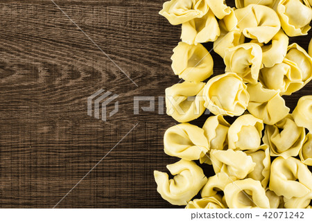 Fresh Raw tortellini pasta on brown wood 42071242