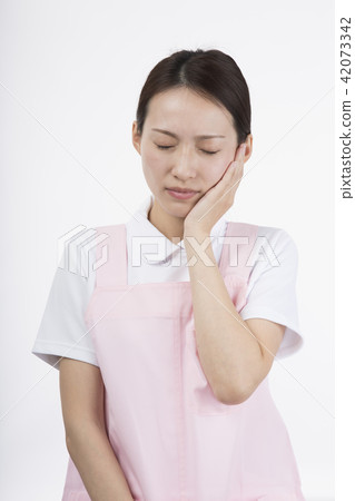 A woman with a white gown and an apron who puts his hand on his cheek and makes a troubled look A woman with a white gown and an apron who puts his hand on his cheek and makes a troubled look 42073342
