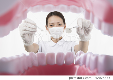 穿著白色衣服的婦女對待與牙齒裝置的牙 42073453