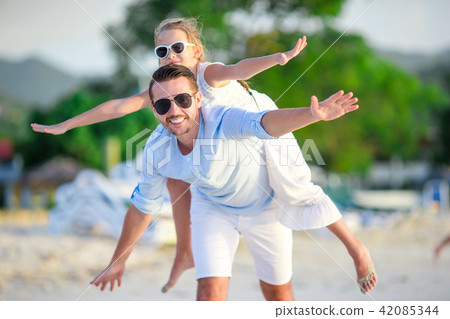 Little girl and happy dad having fun during beach vacation 42085344