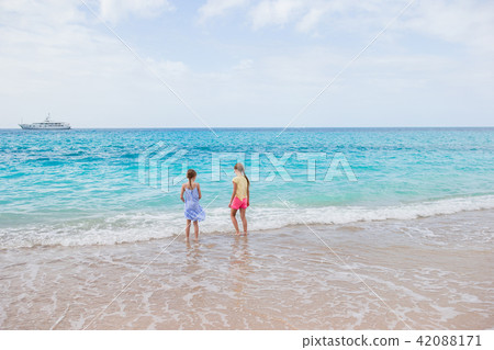 Adorable little girls have a lot of fun on the beach. Adorable little girls have a lot of fun on the beach. 42088171