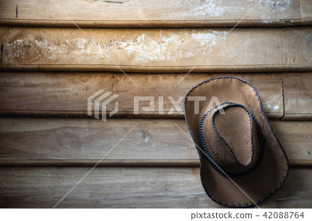 a cowboy hat hangs on grunge wooden wall 42088764