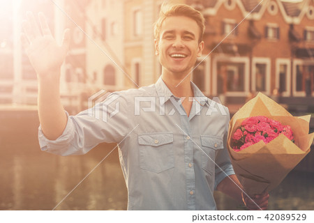 Handsome Guy in Casual Clothes Keeping Flowers 42089529