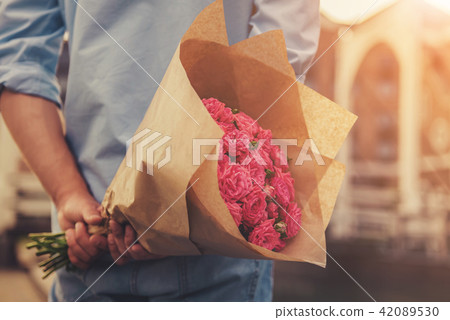 Handsome Guy Holding Flowers Behind His Back 42089530