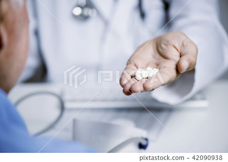 doctor man giving some pills to a senior man 42090938