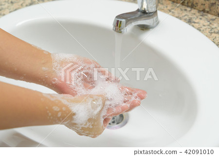 Woman washing hands with soap under the faucet Woman washing hands with soap under the faucet 42091010