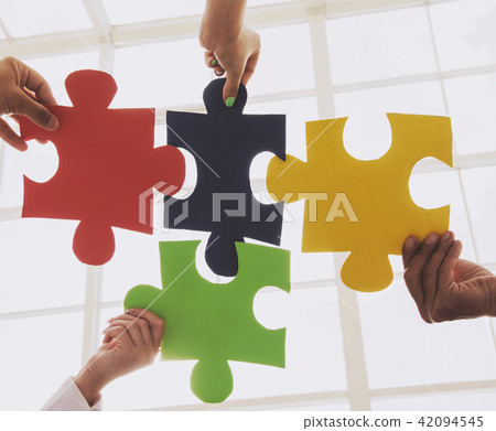 People Put Multicolored Jigsaw Puzzle Together. 42094545