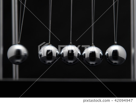 Closeup Of Newton Cradle With Swinging Metal Balls Closeup Of Newton Cradle With Swinging Metal Balls 42094947