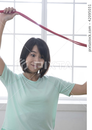 Girl pulling stretch band stretching muscles Girl pulling stretch band stretching muscles 42095031