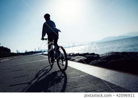 cyclist riding bike in the sunrise coast road 42096911