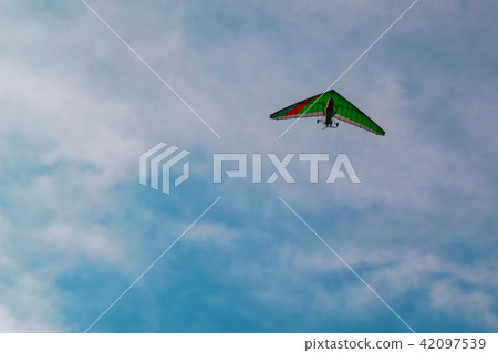 Motorized hang-gliding against blue sky. 42097539
