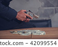Mafia holding gun with ammunition and money 42099554