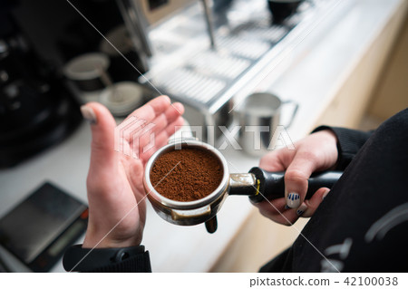 Barista holding portafilter with ground coffee 42100038