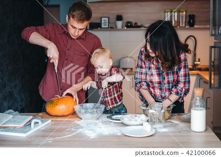 Dad, mom and little son cook a pie Dad, mom and little son cook a pie 42100066