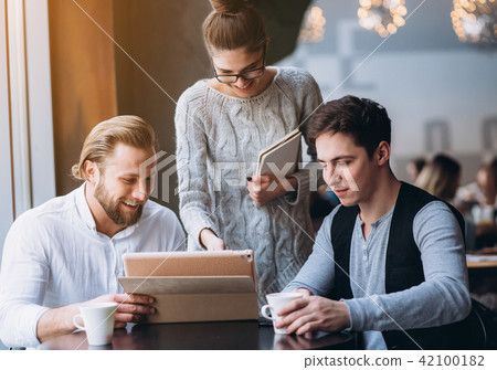 Three Businesspeople Working In cafe Three Businesspeople Working In cafe 42100182