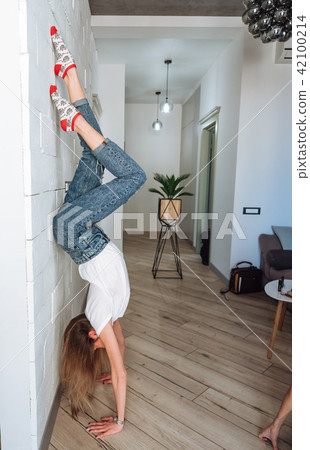 A woman is standing on his hands upside down 42100214
