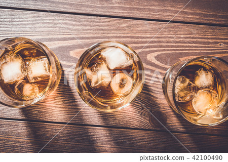 Glasses of whiskey on an old wooden table 42100490