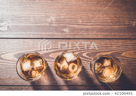 Glasses of whiskey on an old wooden table 42100491
