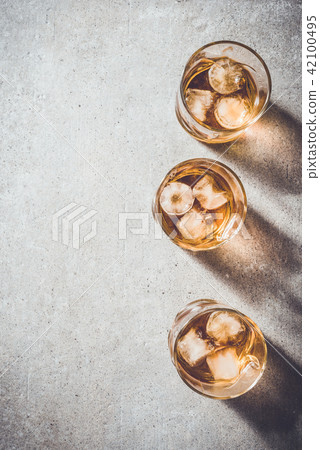 Glasses of whiskey on gray stone table Glasses of whiskey on gray stone table 42100495