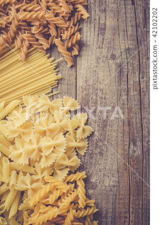 Mix of pasta on an old wooden table Mix of pasta on an old wooden table 42102202
