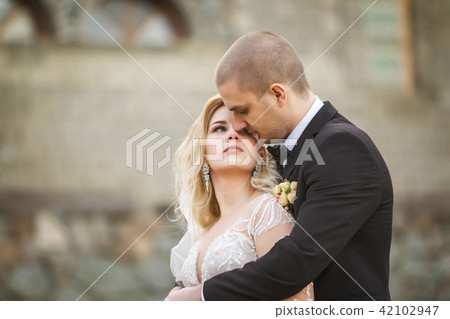 groom embracing bride on the background of old building 42102947