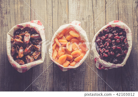 Overhead shot of dried fruits in paper bag 42103012