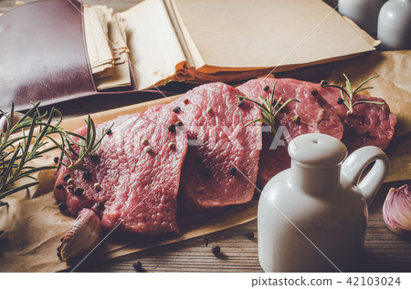 Raw beef steak on wooden table 42103024
