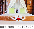 White towel and Chinese rose on bed 42103997