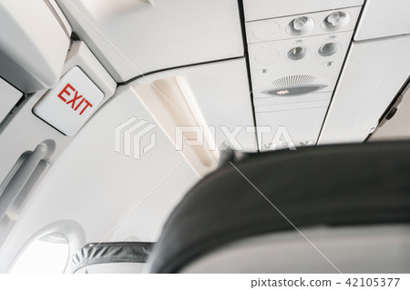 emergency exit sign on airplane. Empty airplane seats in the cabin. Modern Transportation concept 42105377