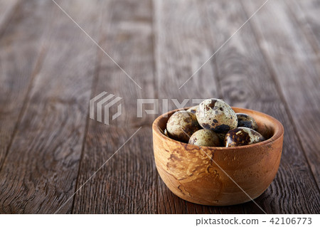Rural still life with bowl full of eggs quail, eggs on a homespun napkin, boxwood on wooden Rural still life with bowl full of eggs quail, eggs on a homespun napkin, boxwood on wooden 42106773