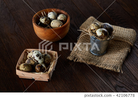 Rural still life with bowl full of eggs quail, eggs on a homespun napkin, boxwood on wooden Rural still life with bowl full of eggs quail, eggs on a homespun napkin, boxwood on wooden 42106778
