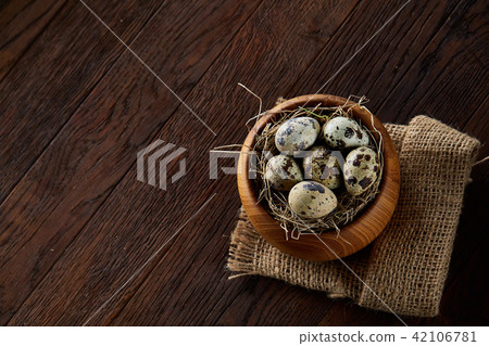 Rural still life with bowl full of eggs quail, eggs on a homespun napkin, boxwood on wooden Rural still life with bowl full of eggs quail, eggs on a homespun napkin, boxwood on wooden 42106781