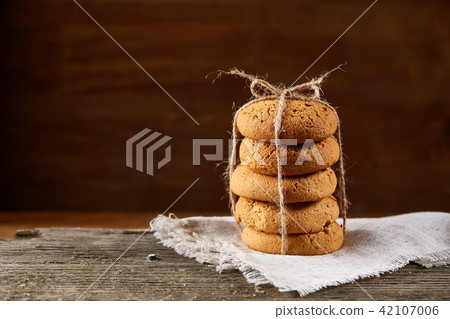 Homemade cookies on homespun napkin over wooden table, close-up, selective focus 42107006