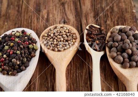 Row of wooden spoons with spices on vintage background, diminishing perspective, close-up, selective 42108040