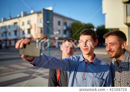 Portrait of a group of smiling and grin friends on summer holiday, making selfie on camera on urban 42108728