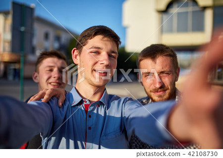 Portrait of a group of smiling and grin friends on summer holiday, making selfie on camera on urban 42108730