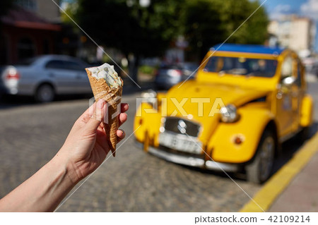A first person view, a person walking along the road with an ice cream in his hands, shallow depth A first person view, a person walking along the road with an ice cream in his hands, shallow depth 42109214