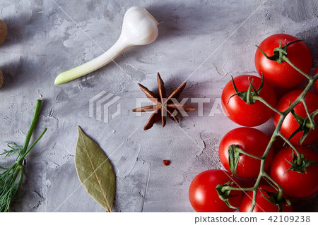 Cherry tomatoes and assorted spices on white textured background, flat lay, close-up, selective Cherry tomatoes and assorted spices on white textured background, flat lay, close-up, selective 42109238