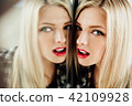 portrait of beautiful young woman blonde girl and her reflection in mirror. 42109928
