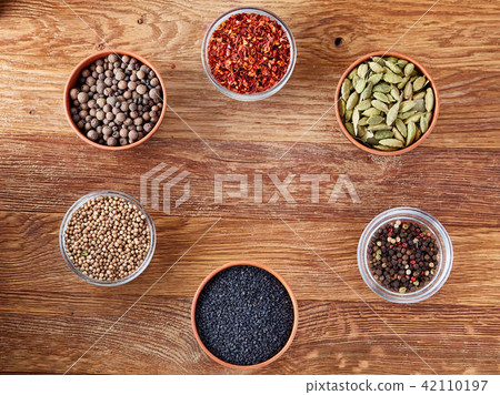 Assortment of spicies arranged in circle on wooden background, top view, close-up, selective focus. 42110197